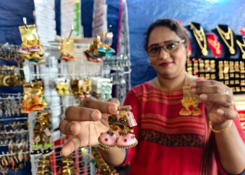 M. KRISTINA menunjukkan perhiasan anting-anting yang dibuatnya sendiri menggunakan benang kain sari ketika ditemui di Karnival Deepavali di Tampin Square, di sini semalam. – UTUSAN/NOR AINNA HAMZAH