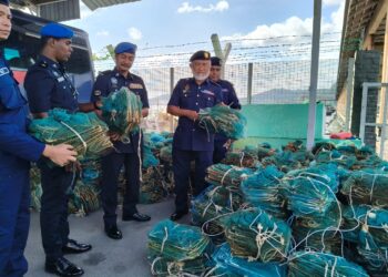 MOHD. Ghazali A. Manap (dua dari kanan) menunjukkan antara barangan rampasan dalam operasi bersama dengan Pasukan Polis Marin di Lumut, Perak hari ini.-UTUSAN/FADZIL ZAINOL