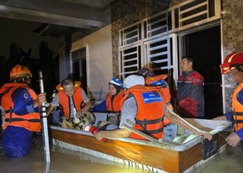 PEGAWAI dan anggota APM Kulim membantu memindahkan penduduk yang terjejas akibat banjir kilat di empat kampung dalam daerah Kulim. - IHSAN APM