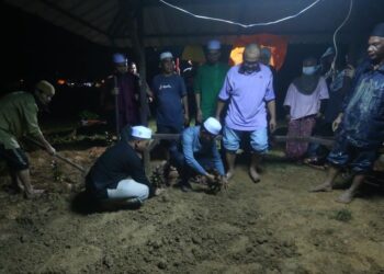 MOHD. Noor Hafifi Hassan (dua kiri) di pusara ibu dan adiknya pada majlis pengebumian di Tanah Perkuburan Islam Masjid Al-Maarif di Jeneri, Sik, malam tadi.