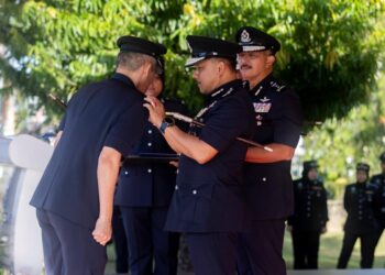 MOHD Yusoff Mamat (kanan) memakaikan pangkat kepada pegawainya pada Majlis Perhimpunan Bulanan Peringkat Ibu Pejabat Polis Kontinjen Kelantan, Kota Bharu, Kelantan hari ini-UTUSAN/KAMARUL BISMI KAMARUZAMAN