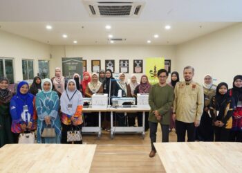 Muhammad Faris Hussain (tiga dari kanan) dan Mohammad Muhaimin Aminuddin bersama peserta kemahiran jahitan di Akademi Siti Khadijah, Nilai, Negeri Sembilan.