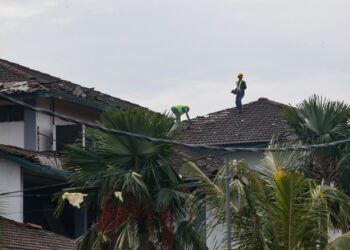 PEKERJA kontraktor membaiki bumbung SK Sijangkang Jaya, Kuala Langat yang rosak selepas dibadai ribut dan puting beliung pada 15 Oktober lalu. – UTUSAN / AFIQ RAZALI