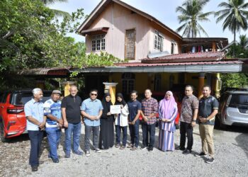 WAN Munadi Wan Mamat (empat kiri) bersama rombongan semasa menyerahkan sumbangan Ahli Skim Emas kepada keluarga Rambo Castello di Jeli, Kelantan hari ini.