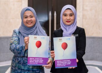 PEGAWAI Mahkamah, Diana Md Razali (kiri) bersama Pegawai Bahagian Hal Ehwal Undang-Undang, Seri Suwarni Nasir (kanan) menunjukkan Buku Garis Panduan Khas Pengendalian Kes-Kes Keselahan Seksual Terhadap Kanak-kanak 2025. - UTUSAN/FAISOL MUSTAFA