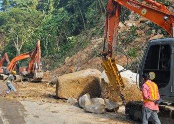 KERJA-KERJA memecah serta mengalihkan batu-batu besar dibuat sebelum pembaikan cerun boleh dilakukan susulan kejadian tanah runtuh di Jalan Tun Sardon, Balik Pulau, Pulau Pinang baru-baru ini.-GAMBAR/FACEBOOK