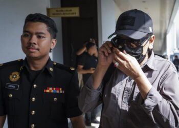 Tertuduh yang merupakan seorang pegawai kanan Angkatan Tentera Malaysia (ATM) bertindak merakam gambar petugas media menggunakan telefon pintarnya ketika keluar dari mahkamah sesyen selepas didakwa atas pertuduhan menerima suapan bernilai RM34,500 sebagai balasan tidak melaporkan aktiviti penyeludupan di Johor, di sini, hari ini. -UTUSAN/MUHAMAD IQBAL ROSLI