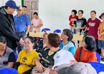 JONISTON beramah mesra dengan penduduk yang hadir pada majlis penyerahan peralatan ICT kepada gereja Katolik Kampung Mantob, di sini, hari ini. - UTUSAN/HARDY JOE