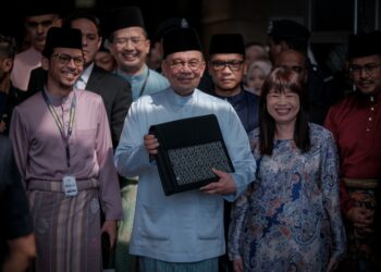 ANWAR Ibrahim menunjukkan beg berisi dokumen Belanjawan 2026 di Kementerian Kewangan Putrajaya. - UTUSAN/FAIZ ALIF ZUBIR