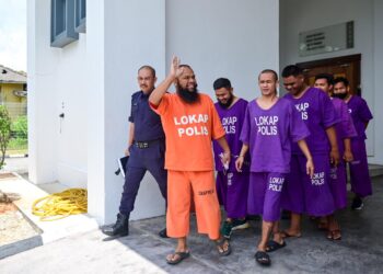 MOHAMAD Azlan Abdullah@Ali (dua dari kiri) ketika dihadapkan ke Mahkamah Sesyen Besut, Terengganu. -UTUSAN/PUQTRA HAIRRY