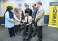MOHD. Hafiz Yusoff (dua dari kanan) melihat kerusi roda elektrik yang disumbangkan kepada Muhammad Nor Syahidan Abdul Manaf pada majlis penyerahan kerosi roda di UniSZA, Gong Badak, Kuala Nerus, Terengganu.