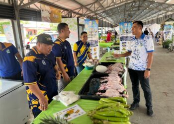 MOHD. Anzara Azizan (kanan) meninjau gerai jualan ayam RM4 yang disediakan bersempena Karnival Jualan Agro Madani@Pasar Tani Kekal Simpang Empat, Perlis hari ini. -UTUSAN/ASYRAF MUHAMMAD