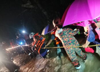 ANGGOTA bomba menyelamatkan lapan sekeluarga yang terperangkap di sebuah dusun di Kampung Wang Perah, Changlun di Kubang Pasu. - IHSAN JBPM KEDAH