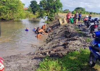 PENDUDUK kampung membantu mencari dua mangsa kanak-kanak yang lemas di tali air Kampung Padang Besar Selatan, Kuala Perlis, Perlis, petang tadi.-UTUSAN