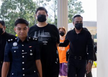 KEDUA-dua tertuduh diiringi polis semasa menghadiri prosiding perbicaraan di Mahkamah Majistret Pasir Mas, Kelantan. - UTUSAN/KAMARUL BISMI KAMARUZAMAN