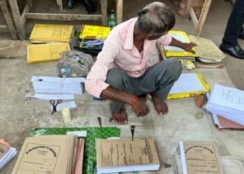 SEORANG lelaki menyusun fail kes di luar Mahkamah Tinggi Allahabad. – AGENSI