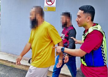 USAHAWAN hartanah (kiri) dan adiknya dibawa keluar dari kamar mahkamah setelah permohonan reman terhadap mereka ditolak di Mahkamah Majistret Marang, Terengganu. - UTUSAN/PUQTRA HAIRRY