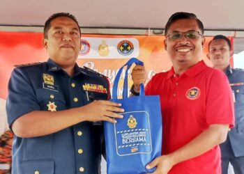 KHAIRUL Anuar Mhd. Sayuti (kiri) menyampaikan cenderamata kepada Mohamad Yusri Bakir (kanan) pada Majlis Penyerahan Bot Bomba Komuniti Sempena Persediaan Monsun Timur Laut (MTL) Zon 4 JBPM Perak Tahun 2025 di Taman Tasik Temoh, Tapah hari ini.
