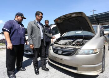 MOHAMMAD Yusoff Abustan (tengah) menunjukkan kenderaan yang dilelong di Pejabat JPJ Negeri Perak di Ipoh.  - UTUSAN/MUHAMAD NAZREEN SYAH MUSTHAFA