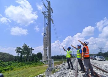SHI LIANG HUI (tengah) menunjukkan tiang kabel terlibas kes kecurian di Seksyen 13 - landasan  Projek Laluan Rel Pantai Timur (ECRL) Kampung Paya Pasir di Maran, Pahang.