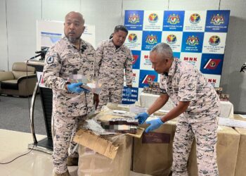 ERWAN Shah Soahdi (kiri) bersama pegawainya menunjukkan rokok putih yang dirampas di Pejabat Maritim Malaysia Kelantan, di Tok Bali, Pasir Puteh, Kelantan.  UTUSAN/TOREK SULONG