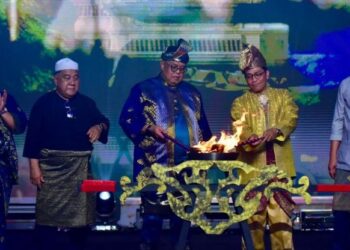 AB. Rauf Yusoh (tengah) melakukan gimik perasmian sempena Festival Seni Selat Melaka di Dataran Pengkalan Rama Pantai, Melaka, malam tadi. - UTUSAN/ARIF HAMIZAN MISKON
