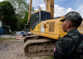 ANGGOTA Pasukan Gerakan Am (PGA) memantau kerja-kerja merobohkan pangkalan haram Gergaji di Rantau Panjang, Kelantan hari ini. - UTUSAN/KAMARUL BISMI KAMARUZAMAN