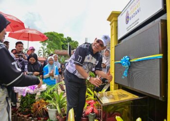 SAIFUDDIN Nasution Ismail (tengah) menandatangani plak pada Majlis Sambutan Hari Pendaftaran Negara ke-77 dan Peluncuran Sekolah Angkat Madani Jabatan Pendaftaran Negara di Sekolah Menengah Kebangsaan Agama (SMKA) Sheikh Abdul Malik, Kuala Terengganu.- UTUSAN/PUQTRA HAIRRY