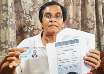 MOHD. RAWI Abdullah menunjukkan kad pengenalan baharunya dan semakan baki SARA yang berkurangan dan mendakwa telah digunakan oleh orang lain. - UTUSAN/FADZIL ZAINOL
