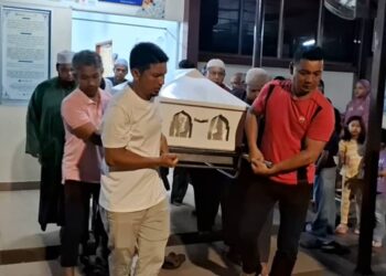 SYAFIQ Azril Mohd. Nasis (kiri) mengusung jenazah  Nor Hidayah Zakaria di Unit Forensik Hospital Kemaman, sebelum dibawa pulang ke Jitra, Kedah. -UTUSAN/NIK NUR IZZATUL HAZWANI NIK ADNAN