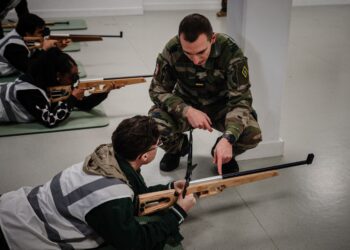 ANGGOTA tentera mengajar seorang peserta melakukan latihan menembak semasa Hari Tentera di Arcueil, Perancis. – AFP