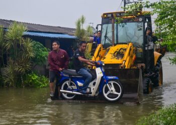 PENDUDUK mengangkut motor menggunakan jentolak selepas rumah mereka ditenggelami banjir di Taman Perumahan Awam Kos Rendah Bukit Payung,  Marang, Terengganu. - UTUSAN/PUQTRA HAIRRY