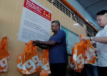 ARUL Kumar (kiri) pada program Kempen Beg Beli-Belah Guna Semula dan Kongsi Sama di Pasar Besar Seremban hari ini. - UTUSAN/MOHD. SHAHJEHAN MAAMIN