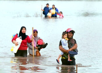 BEBERAPA keluarga mula keluar meninggalkan kediaman masing-masing dengan membawa keperluan penting untuk ke Pusat Pemindahan Sementara (PPS) berdekatan yang sudah dibuka sejak semalam. - UTUSAN/IZLIZAN OTHMAN