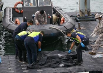 ANGGOTA polis dan Maritim Malaysia memeriksa mayat disyaki pendatang asing tanpa izin yang ditemukan di perairan Malaysia dekat Langkawi, semalam. – UTUSAN/SHAHIR NOORDIN
