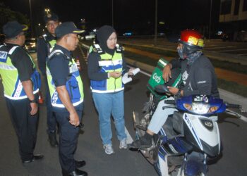 SITI Zarina Mohd. Yusof mengetuai pemeriksaan terhadap seorang penunggang motosikal dalam sekatan jalan raya Op Bersepadu Bersama Agensi di Jalan Syed Abdul Aziz dekat Limbungan, Melaka, semalam. - UTUSAN/AMRAN MULUP