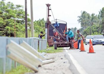 PEKERJA kontraktor melakukan pemasangan penghadang jalan di salah satu lokasi yang berisiko tinggi berlaku kemalangan di Jalan Sungai Korok, Jitra di Kubang Pasu, semalam. – UTUSAN/SHAHIR NOORDIN
