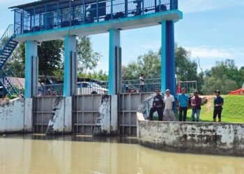 PENDUDUK menunjukkan kunci air di Kampung Parit Satu Baruh di Hutan Melintang, Bagan Datuk. – UTUSAN/AIN SAFRE BIDIN