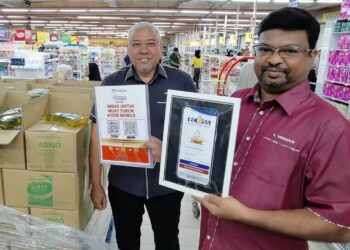 S. VEERAPAN (kanan) menunjukkan penggunaan e-COSS di sebuah pasar raya di Senawang, Seremban hari ini.-UTUSAN/ MOHD SHAHJEHAN MAAMIN.