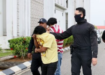 KEDUA-DUA tertuduh dibawa polis semasa menghadiri prosiding perbicaraan di Mahkamah Sesyen Kota Bharu, Kelantan-. - UTUSAN/ KAMARUL BISMI KAMARUZAMAN