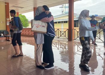 NORHANANI Ahmad memeluk anak keduanya yang baharu tiba dari Kolej Pertanian Bukit Tangga, Bukit Kayu Hitam, Kedah di HTF, Kangar, Perlis hari ini. - UTUSAN/ASYRAF MUHAMMAD