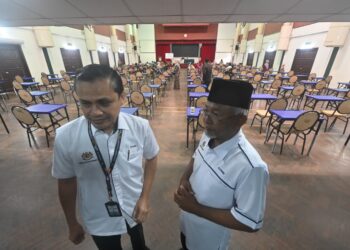 AHMAD Zamri Md. Isa (kiri) meninjau keadaan dewan untuk calon persendirian peperiksaan SPM di Universiti Islam Pahang Sultan Ahmad Shah (UnIPSAS) di Kuantan, Pahang. - UTUSAN/SHAIKH AHMAD RAZIF