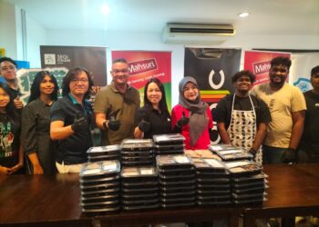 MOHD. Jazri Ikmal Hijaz (lima dari kiri) dan Leong Mi-Chelle ( tengah) membantu menyediakan bento di Kolej SEGi Pulau Pinang untuk diedarkan ke rumah-rumah kebajikan di sekitar George Town, Pulau Pinang semalam. – UTUSAN/SAFINA RAMLI
