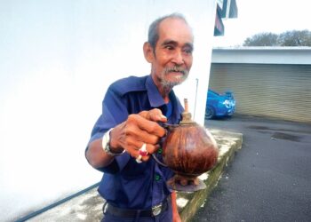 CHE Mat Ahmad menunjukkan pelita tradisional daripada buah kelapa tua yang mendapat permintaan khususnya menjelang sambutan Hari Raya Aidilfitri. – UTUSAN/SALEHUDIN MAT RASAD