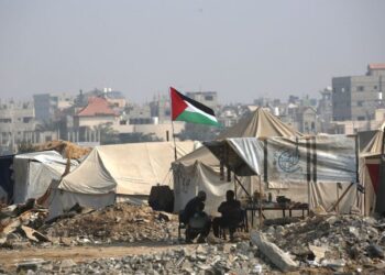 RAKYAT Palestin duduk di luar kediaman sementara di sepanjang jalan berhampiran kem pelarian Nuseirat di tengah Gaza.- AFP
