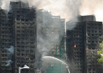 PASUKAN bomba memadam kebakaran di blok pangsapuri yang terbakar di Hong Kong. – AFP