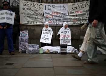 AHLI kumpulan Grieving for Gaza memegang plakad dan sepanduk semasa bantahan di luar pintu bangunan Parlimen di pusat bandar London.-AFP