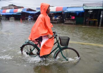 SEORANG penduduk menunggang basikal melalui deretan gerai yang ditenggelami air susulan hujan lebat di Narathiwat di selatan Thailand-AFP
