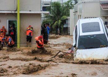 ANGGOTA penyelamat meredah banjir dalam operasi untuk memindahkan mangsa yang terperangkap di rumah mereka di Padang, wilayah Sumatera Barat.- AFP