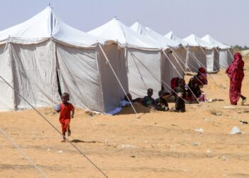 KANAK-kanak Sudan yang berjaya melarikan diri dari al-Fashir duduk di luar khemah di kawasan perlindungan bandar utara Al-Dabba.- AFP